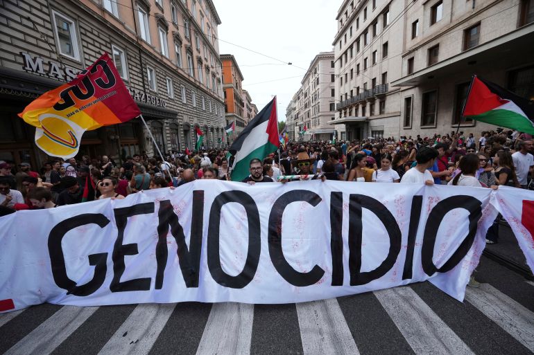 People hold a banner reading "genocide" as they participate at a demonstration.